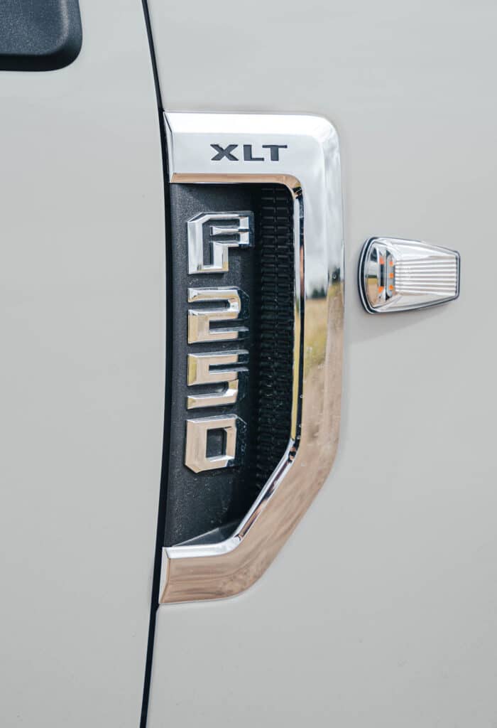 A close-up on the side of a white Ford F-250 Platinum, showing the F-250 logo.